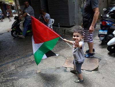 A boy carries a flag of Palestine in the camp at Shatila. AFP