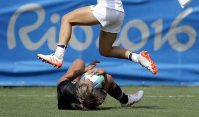 France's Pauline Biscarat, top, jumps over New Zealand's Huriana Manuel, after she scored a try during the women's rugby sevens match at the Summer Olympics in Rio de Janeiro, Brazil, Sunday, Aug. 7, 2016. (AP Photo/Themba Hadebe)