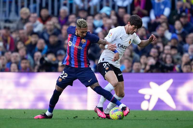 Barcelona's Raphinha fights for the ball with Valencia's Vazquez Alcalde. EPA