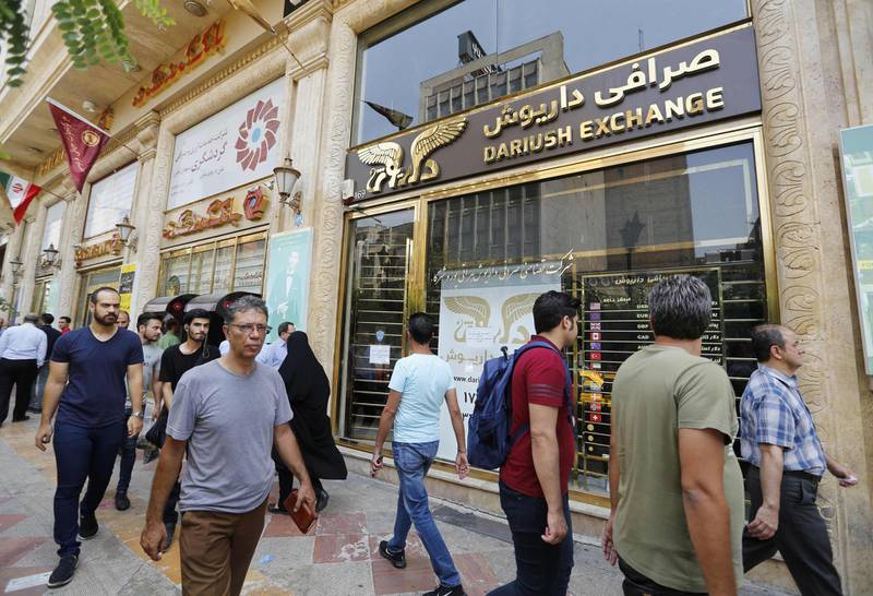 (FILES) In this file photo taken on August 8, 2018 people walk in front of a currency exchange shop in the Iranian capital Tehran. - Iran told the UN's top court on August 29, 2018 that "time is running out" for its people as they suffer economic turmoil that Tehran blames on renewed US sanctions. Iran was making its closing arguments in a challenge to the sanctions at the International Court of Justice in The Hague. (Photo by ATTA KENARE / AFP)