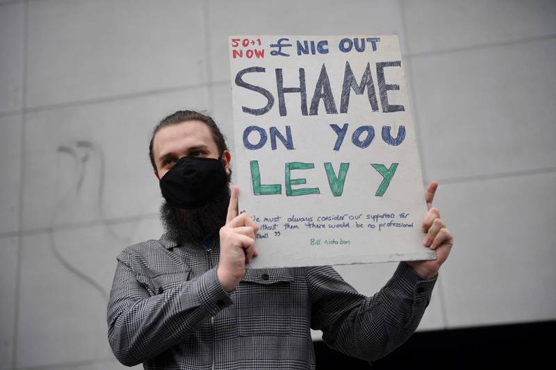 A fan holds a poster reacting to the collapse of the planned creation of a European Super League, outside the Tottenham Hotspur Stadium in north London on April 21, 2021, ahead of the English Premier League football match against Southampton. AFP