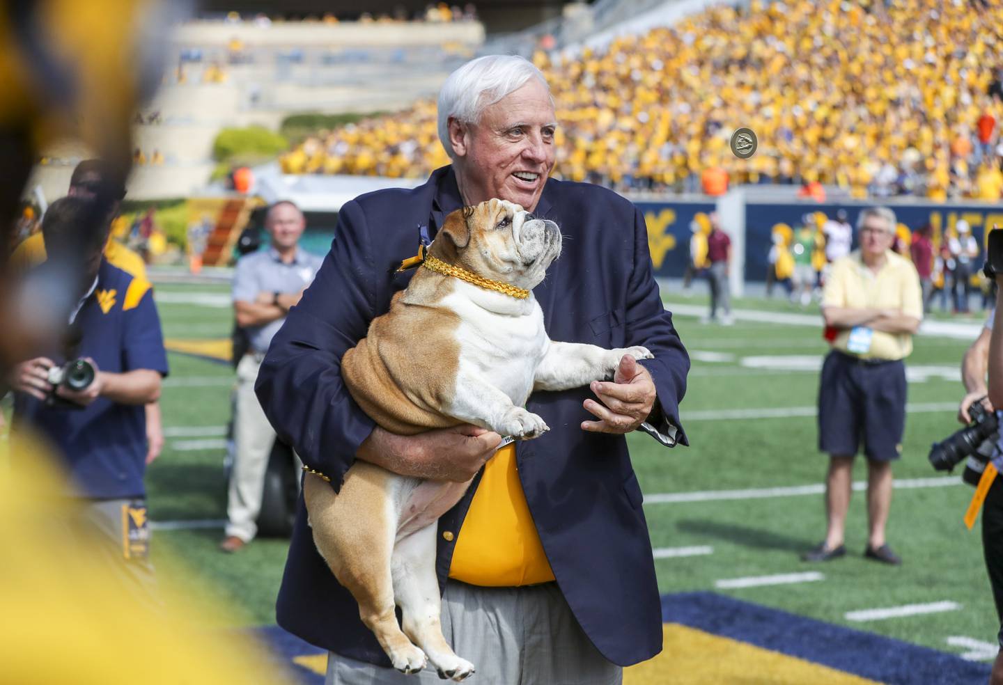 Jim Justice and his dog, Babydog, flip the coin to begin the American football game at Mountaineer Field at Milan Puskar Stadium. Phot: USA TODAY Sports