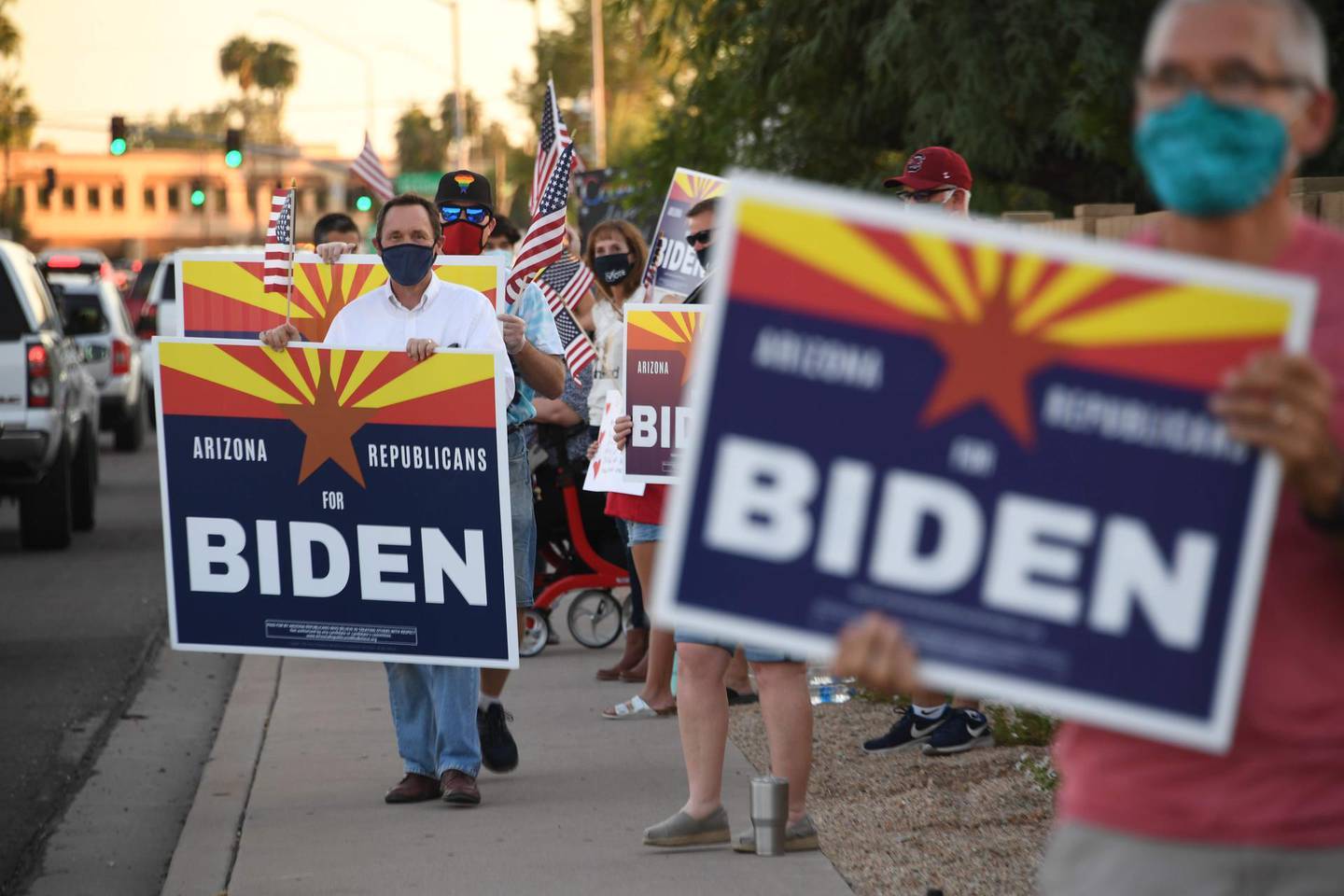 Members of the group "Arizona Republicans Who Believe In Treating Others With Respect" wave flags and hold signs in support of Democratic presidential candidate Joe Biden, during evening rush hour in Phoenix, Arizona on October 16, 2020. Arizona is one of the swing states that will determine the outcome of the November 3 US presidential election between Biden and US President Donald Trump. / AFP / Robyn Beck
