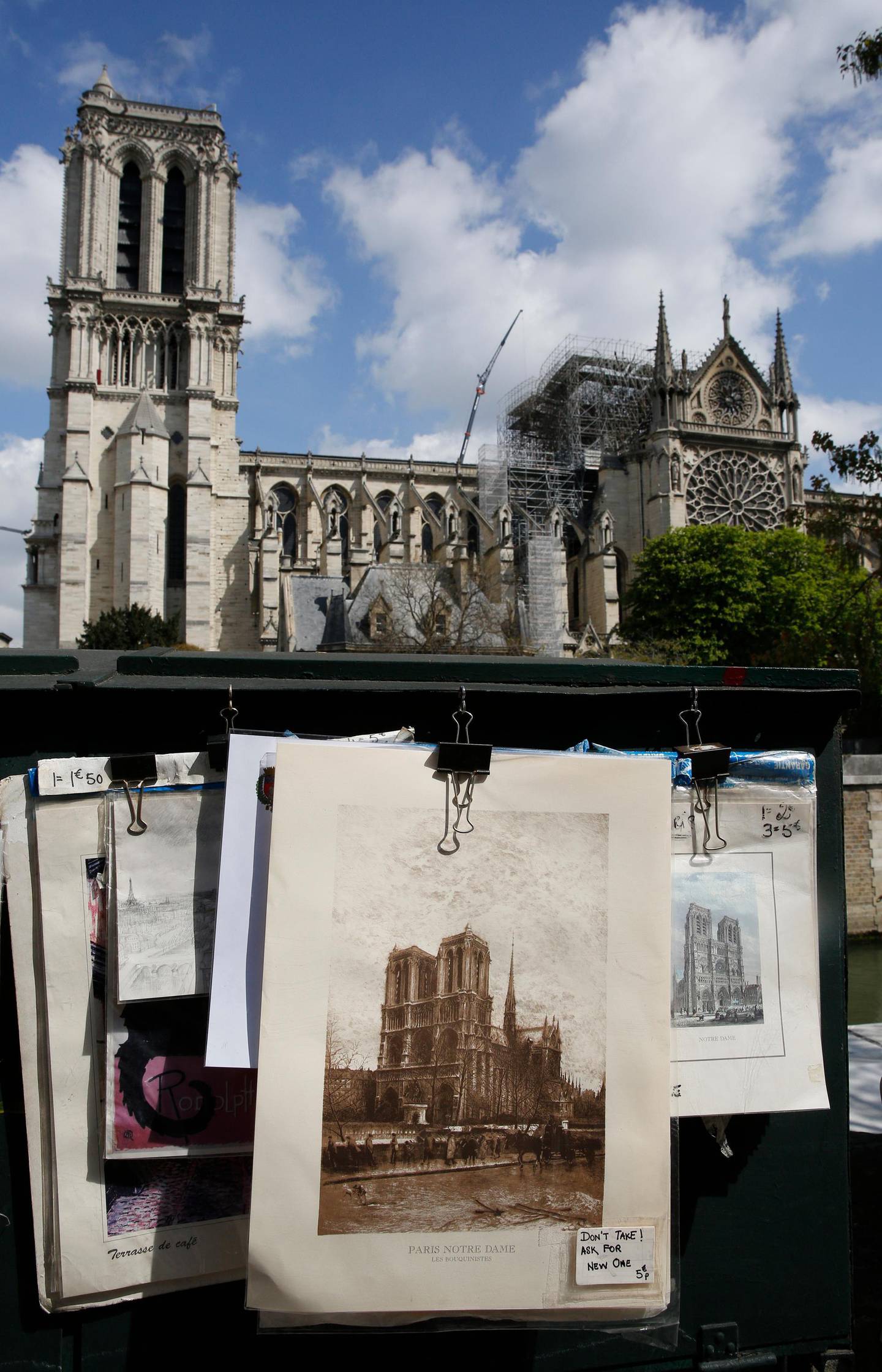 Prints of the cathedral of Notre Dame at a venders stall on the Left Bank with the cathedral of Notre Dame in the background in Paris, Wednesday, April 17, 2019. Nearly $1 billion has already poured in from ordinary worshippers and high-powered magnates around the world to restore the Notre Dame in Paris after a massive fire. (AP Photo/Christophe Ena)
