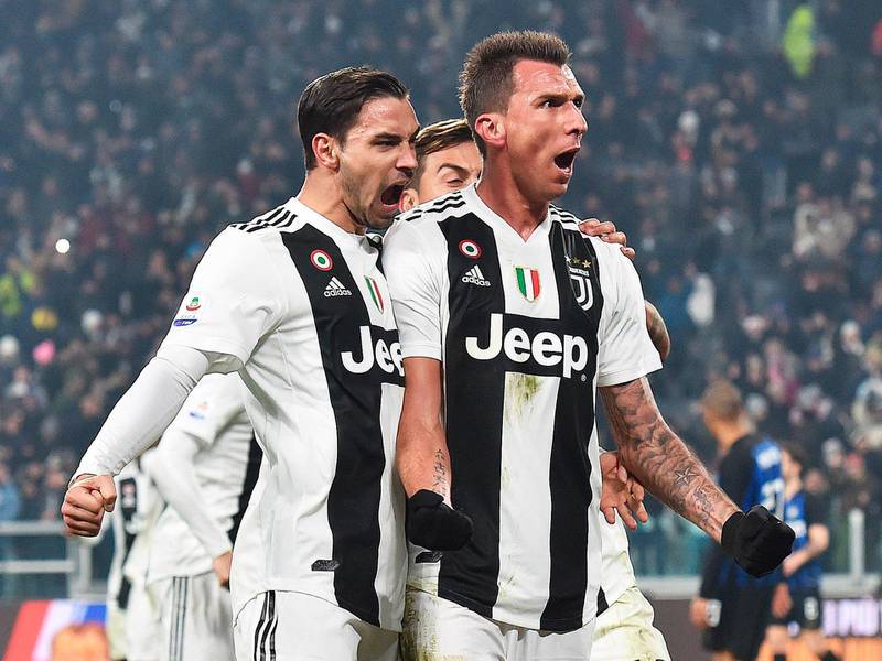 Juventus' Mario Mandzukic, right, celebrates with teammate Mattia De Sciglio, left, and Paulo Dybala after scoring his side's opening goal  during the Serie A soccer match between Juventus and Inter Milan at the Turin Allianz stadium, Italy, Friday, Dec. 7, 2018. (Andrea Di Marco/ANSA via AP)
