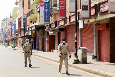Police personnel patrol along a street during the weekend lockdown imposed by the state government as a preventive measure against the spread of Covid-19 coronavirus in Amritsar on May 8, 2021, as India recorded more than 4,000 coronavirus deaths in a day for the first time. / AFP / Narinder NANU
