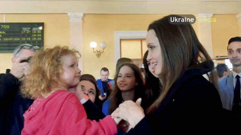 Jolie interacts with a child at the main railway station during her visit to Lviv. Reuters