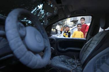 Palestinian children inspect a damaged car following Israeli bombardment in Rafah in the southern Gaza Strip, on October 18, 2023, amid ongoing battles between Israel and the Palestinian group Hamas.  US President Joe Bidden landed in Tel Aviv on October 18 as Middle East anger flared after hundreds were killed in a hospital blast in war-torn Gaza, for which Israel and the Palestinians immediately traded blame.  (Photo by SAID KHATIB  /  AFP)