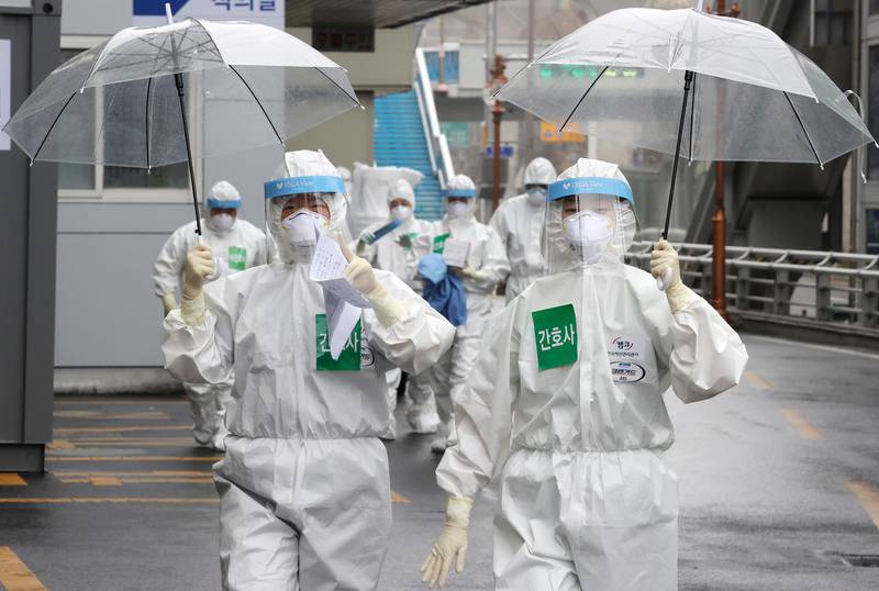 Medical staff members gesture as they arrive for a duty shift at Dongsan Hospital in Daegu, South Korea. Newsis via AP