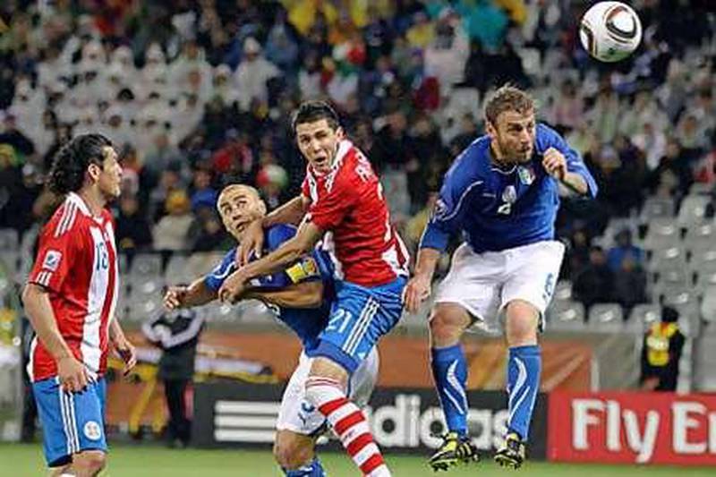 Paraguay's Antolin Alcaraz heads in the goal after beating Fabio Cannavaro, second from left, and Daniele De Rossi in the aerial challenge.