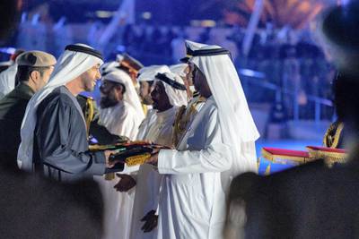 ABU DHABI, UNITED ARAB EMIRATES - November 30, 2019: HH Sheikh Mohamed bin Zayed Al Nahyan Crown Prince of Abu Dhabi Deputy Supreme Commander of the UAE Armed Forces (L), presents a medal to a family member of a martyr who passed away within this year, during a Commemoration Day ceremony at Wahat Al Karama.

( Hamad Al Kaabi / Ministry of Presidential Affairs )​
---