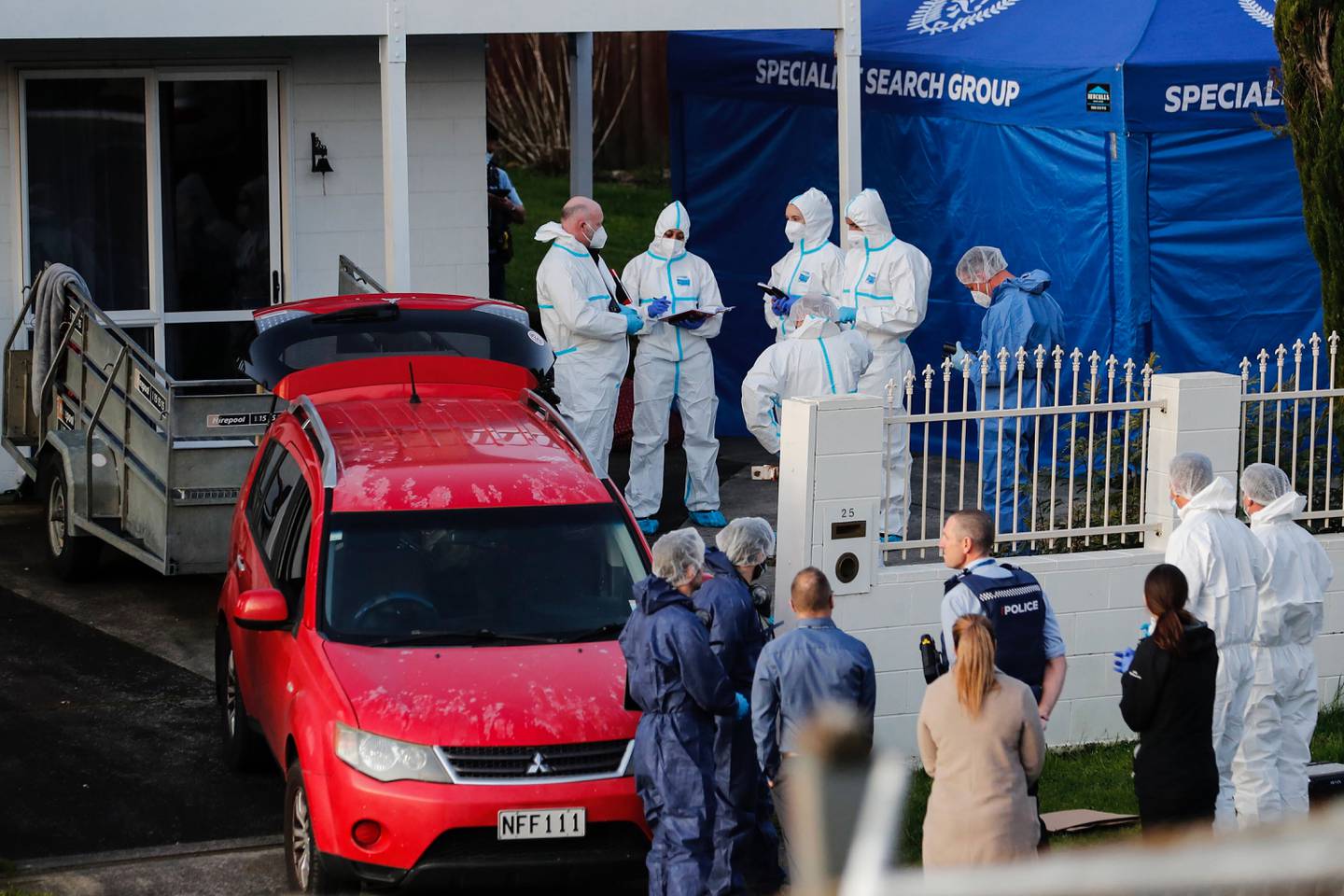 Police investigators in Auckland on August 11 after the remains were discovered in suitcases bought at an auction. AP