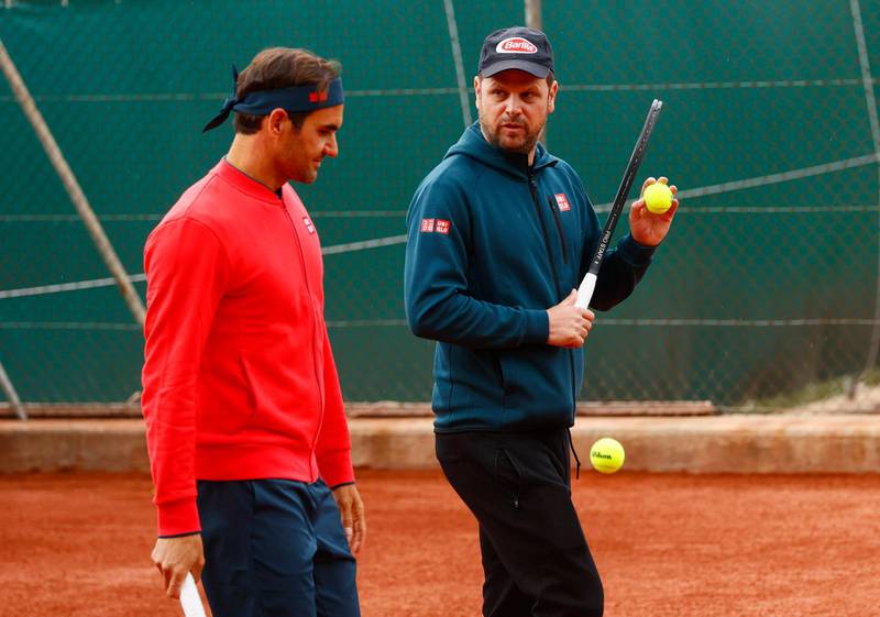 Roger Federer and coach Severin Luethi during training. Reuters