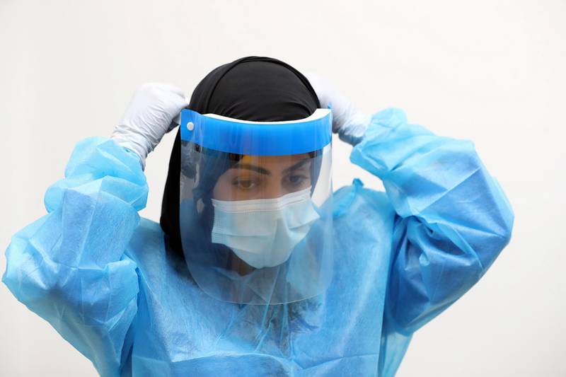 Nurse Rouda Salem Al Hameli puts on her PPE during a visit to the SEHA field hospital for Covid-19 patients in Sharjah on April 25th, 2021. Chris Whiteoak / The National. 
Reporter: Kelly Clarke for News
