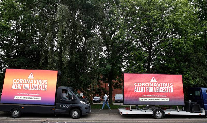 A woman walks past advertising trucks carrying a coronavirus warning during local lockdown in Leicester, England.  The UK Government announced that Pubs, Hotels and Restaurants can open from Saturday, July 4th providing they follow guidelines on social distancing and sanitising, whilst the city of Leicester remains in lockdown following a spike in coronavirus cases. Getty Images