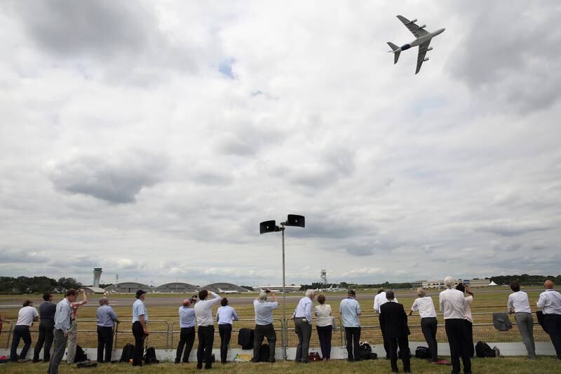 Visitors take pictures as an Airbus A380 performs for the Farnborough Airshow crowd in 2014.