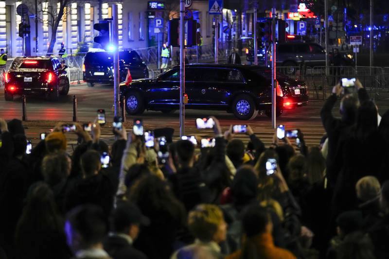 People take pictures as the motorcade with the US President arrives at the Marriot hotel in Warsaw. AP