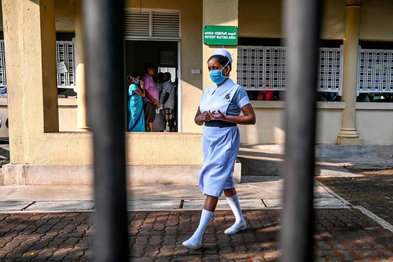 A nurse wearing a facemask walks outside the entrance of Sri Lanka's Infectious Diseases Hospital near Colombo.  AFP