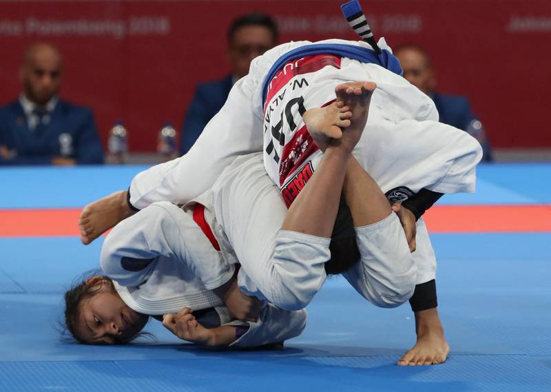 Jenna Kaila Napolis, left, of the Philippines in action against the UAE's Wadima Al Yafei, right, during the women's 49kg match. Adi Weda / EPA