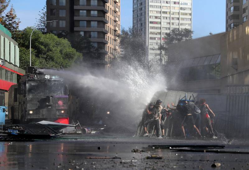 A riot police water cannon sprays water towards demonstrators during a protest against Chile's state economic model in Santiago, Chile. Reuters