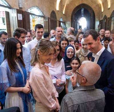 Syria's president and his wife greet people at Aleppo's historic souk. AFP