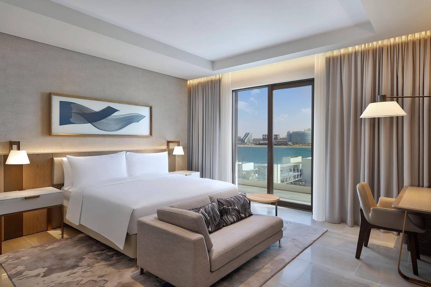 A one-bedroom suite at Hilton Abu Dhabi Yas Island sleeps two adults and two children, has a separate lounge and dining area, and a spacious balcony with bay views. Courtesy Hilton