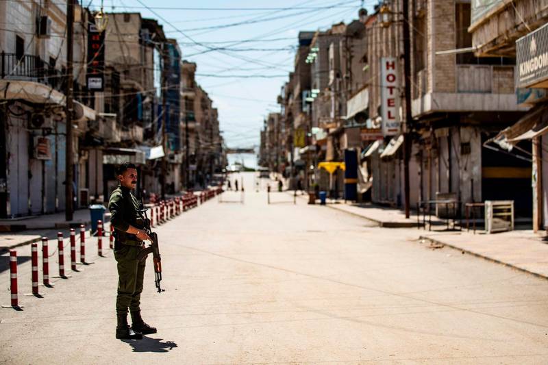 A member of the Kurdish internal security forces stands in the middle of an empty road in the city of Qamishli in Syria's northeastern Hasakeh province a day after local authorities of the Kurdish-dominated northern part of war-torn Syria recorded its first death due to the coronavirus outbreak. AFP
