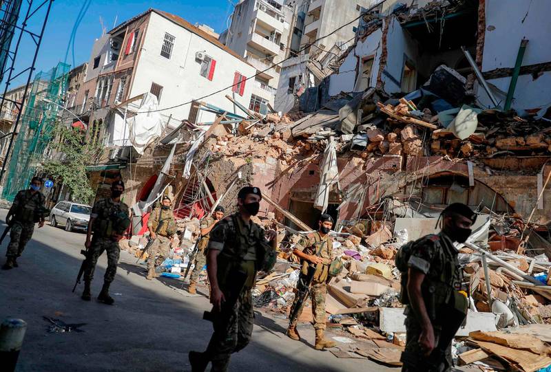 Lebanese soldiers walk past a partially destroyed traditional building which was afffected by the Beirut port blast, in the Gemmayzeh neighbourhood, on August 26, 2020. A massive fertiliser explosion at the Beirut port on August 4 that many blame on official negligence killed more than 180 people, wounded thousands, and laid waste to some of the capital's most picturesque neighbourhoods. Now with survivors still picking through the rubble, property sharks are moving in to take advantage of distraught home owners, sparking outrage over yet another disaster in the making, this time targeting the country's heritage. / AFP / JOSEPH EID

