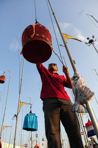 A participant hangs his birdcage. AFP