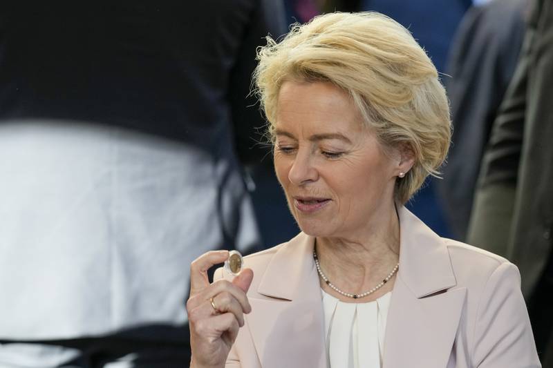 Ursula von der Leyen, President of the European Commission, with a euro coin at a cafe in Zagreb. AP