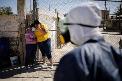 Relatives react outside a house where a person died from Covid-19 in Ciudad Juarez, Mexico. Reuters