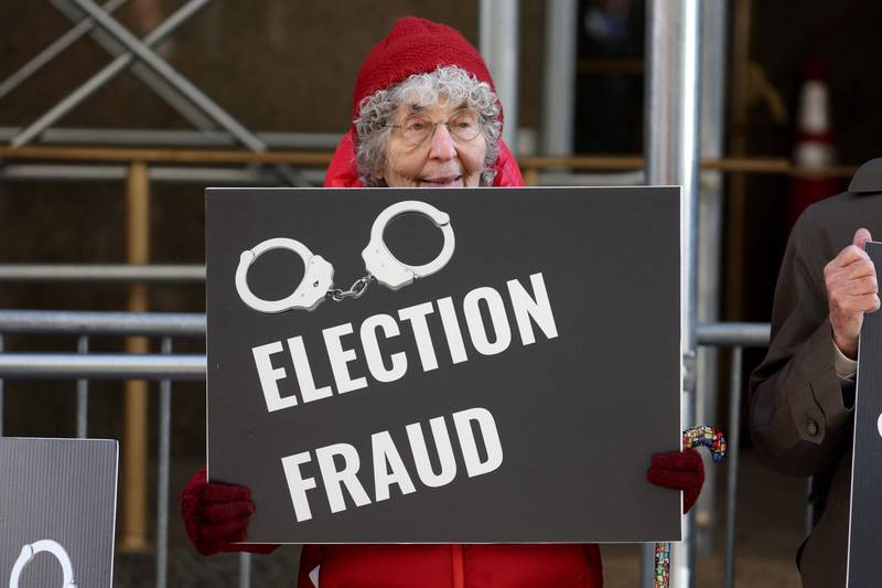 A demonstrator holds a sign outside Manhattan Criminal Court as a grand jury is expected to vote this week on whether to indict Mr Trump. Getty 