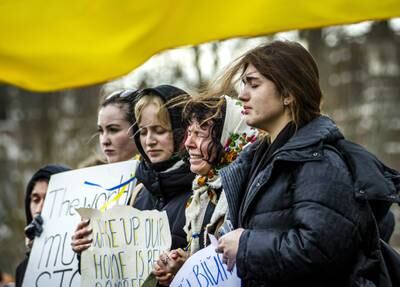 People carry Ukrainian flags and signs reading 'Stop War' and 'Stop Russia' as they protest at the Russian embassy in the Hague, the Netherlands. EPA