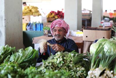 A man wearing a protective face mask slices vegetables at a market in Qatif, Saudi Arabia March 9, 2020. Reuters