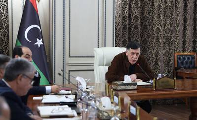 Libya's UN-recognised Prime Minister Fayez al-Sarraj holds a cabinet meeting in the Libyan capital Tripoli on December 19, 2019.  Libya's UN-recognised Government of National Accord (GNA) approved the implementation of a military deal with Turkey, paving the way for a bigger role for Ankara in the conflict-hit country. The GNA, which met in the presence of military officials, gave no further details about the terms of the agreement or the assistance Ankara could provide to pro-GNA forces facing an offensive by east Libyan military strongman Khalifa Haftar. / AFP / -
