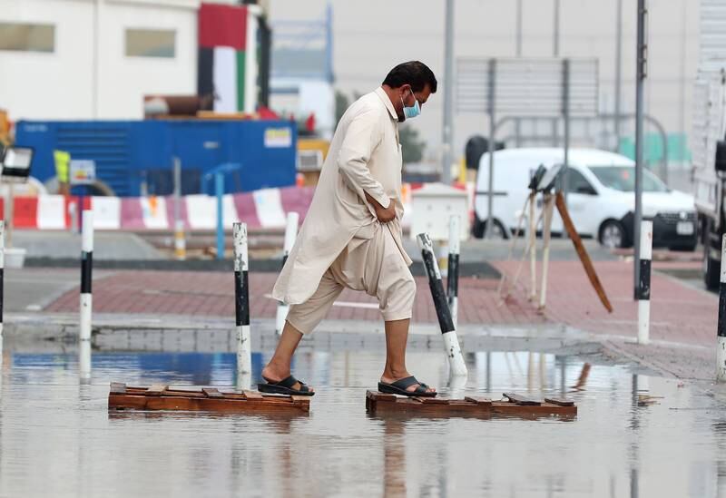 A man navigates a deluged street in Al Quoz, Dubai. Chris Whiteoak / The National