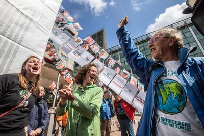 Members of the environmental group MilieuDefensie celebrate the verdict of the Dutch environmental organisation's case against Royal Dutch Shell Plc, outside the Palace of Justice courthouse in The Hague, Netherlands, on Wednesday, May 26, 2021. Shell was ordered by a Dutch court to slash its emissions harder and faster than planned, dealing a blow to the oil giant that could have far reaching consequences for the rest of the global fossil fuel industry. Photographer: Peter Boer/Bloomberg
