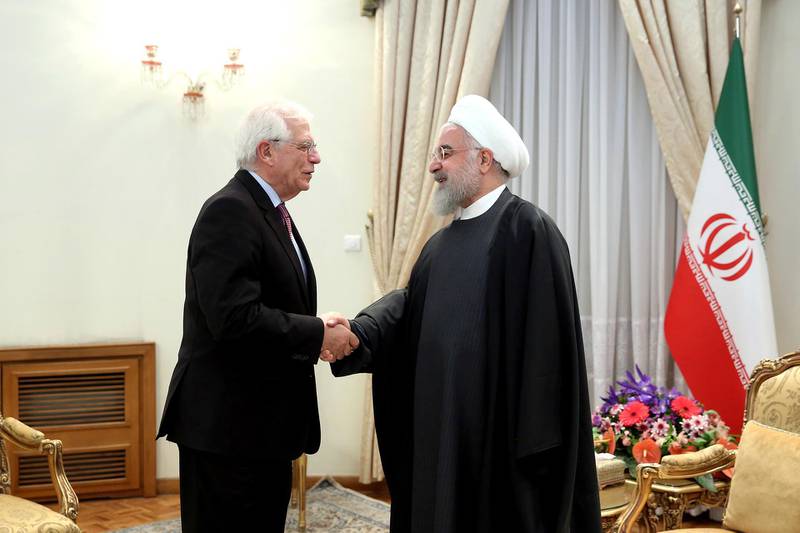 In this photo released by the official website of the Office of the Iranian Presidency, President Hassan Rouhani, right, welcomes European Union foreign policy chief Josep Borrell for their meeting in Tehran, Iran, Monday, Feb. 3, 2020. (Office of the Iranian Presidency via AP)