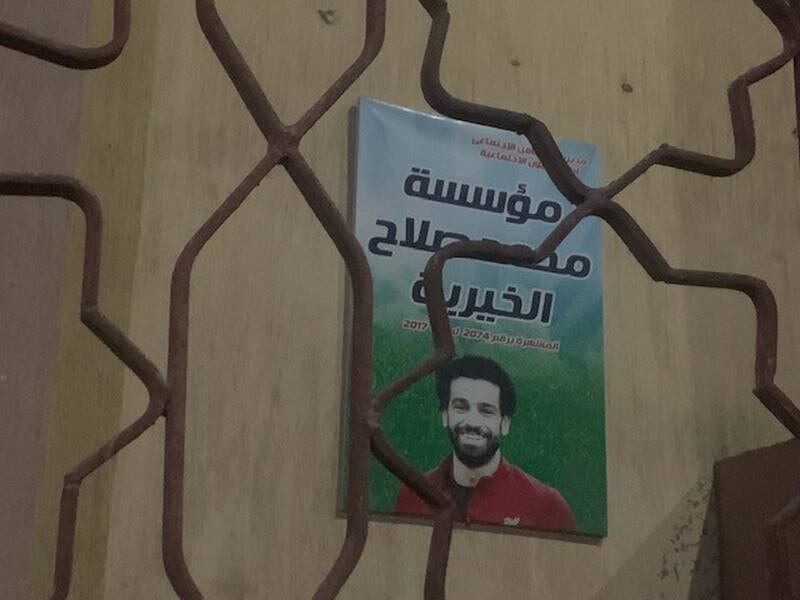 A sign bearing the image of a smiling Mohamed Salah marks the headquarters of the player's charity. Photo: Hamza Hendawi / The National