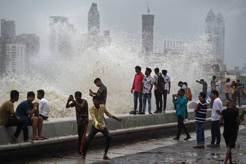 People enjoying high tides splashing on the sea front in  Mumbai.  AFP