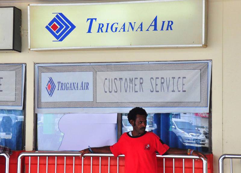 A Papuan man stands in front of a closed Trigana Air service counter, its glass window shattered by relatives of passengers killed on the ill-fated flight, at Sentani airport in Jayapura on August 18, 2015. Thirty-eight bodies have been found at the site in remote eastern Indonesia where a plane crashed at the weekend, the transport ministry said. The plane that went down in eastern Indonesian carrying 54 people and large sums of money was "completely destroyed", an official said on August 18, after rescuers finally reached the remote crash site of the Trigana Air ATR 42-300 twin-turboprop plane. AFP PHOTO / INDRAYADI THAMRIN (Photo by INDRAYADI THAMRIN / AFP)