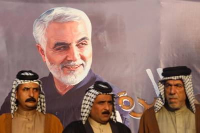 Iraqi tribal sheikhs stand next to the portraits of Iranian Revolutionary Guards commander Qasem Soleimani during a demonstration in Baghdad's western Shoala neighbourhood. AFP