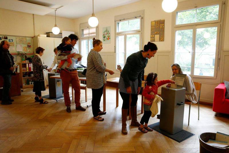 People cast their ballots in a school in Bern, Switzerland, June 5, 2016. Voters are deciding on whether to give every adult citizen a basic guaranteed monthly income of 2,500 Swiss francs. Ruben Sprich/Reuters