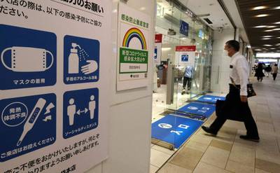 A sign with guidelines on preventing the spread of Covid-19 is displayed at an entrance to a department store in Tokyo. AFP