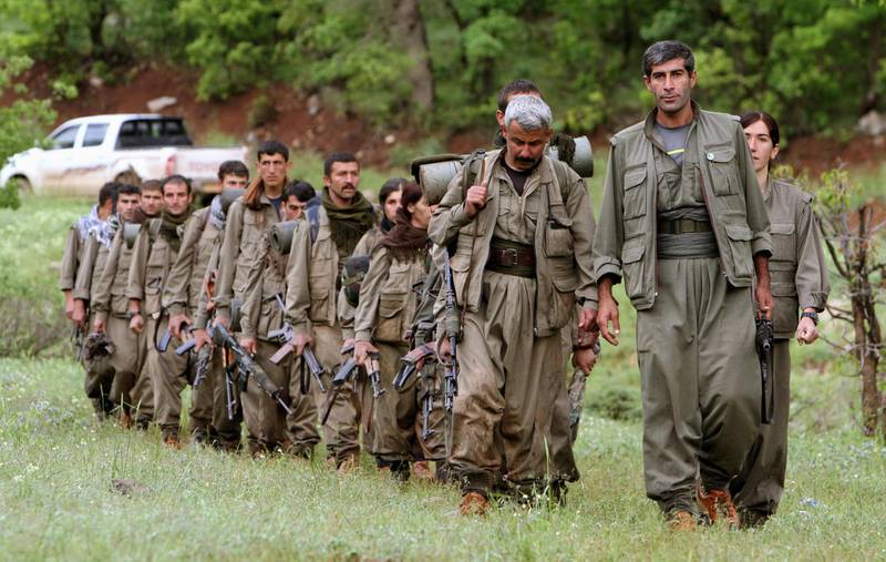 FILE - in this Tuesday, May 14, 2013 file photo, a group of armed Kurdish fighters from the Kurdistan Workers Party (PKK) enter northern Iraq in the Heror area, northeast of Dahuk, 260 miles (430 kilometers) northwest of Baghdad, Iraq. A Kurdish rebel group says they are withdrawing from Iraq's Sinjar following threats of attack from Turkey. The Kurdistan Workers Party, or PKK, says in a statement Friday, March 23, 2018 the "Iraqi government's position and the fact that the Kurdish community had managed to organize itself" have removed security fears in the area. (AP Photo/Ceerwan Aziz, File)