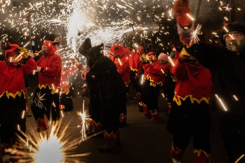 Revellers dressed as devils hold torches with firecrackers as they take part in a fire-run during the Sant Antoni festival in Barcelona, Spain.  Getty