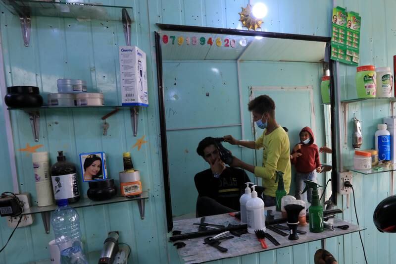A Syrian barber at work in Zaatari. EPA