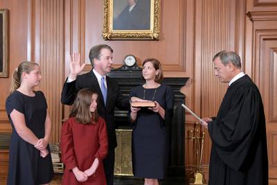 Judge Brett Kavanaugh is sworn in as an Associate Justice of the U.S. Supreme Court by Chief Justice John Roberts as Kavanaugh's wife Ashley holds the family bible and his daughters Liza and Margaret look on in a handout photo provided by the U.S. Supreme Court taken at the Supreme Court building in Washington, U.S., October 6, 2018.  Fred Schilling/Collection of the Supreme Court of the United States/Handout via Reuters ATTENTION EDITORS - THIS IMAGE WAS PROVIDED BY A THIRD PARTY.      TPX IMAGES OF THE DAY