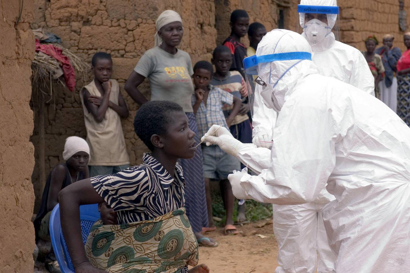 Un membre de l'Organisation mondiale de la santé prélève un échantillon oral d'un patient suspecté d'avoir Marburg.  AFP PHOTO QUI 