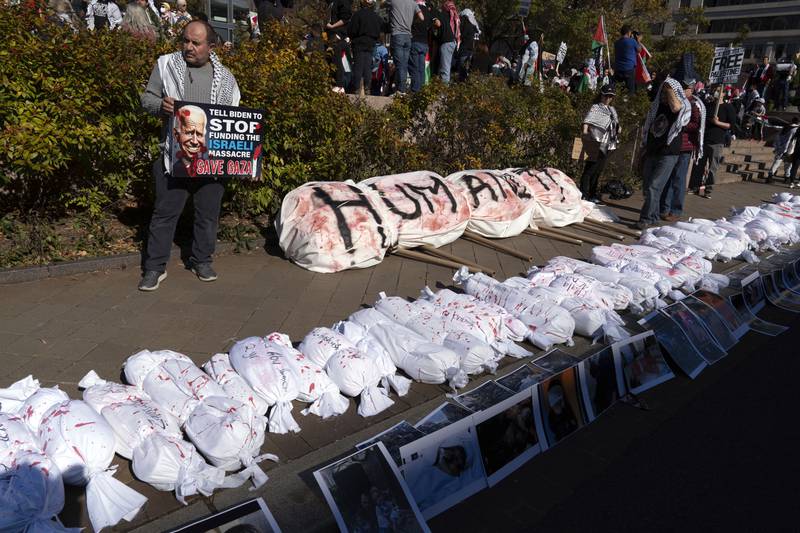Protesters lay white sacks on the ground, representing the bodies of people killed in Gaza, during the protest. AP